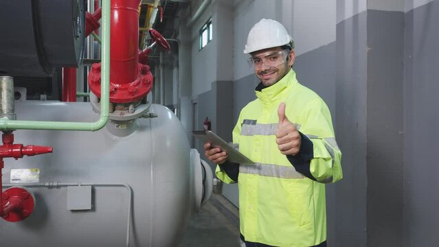 Industrial engineer using digital tablet inspect and thumbs up. Engineer male working at factory. Concept of industry, factory, environment and professional people.