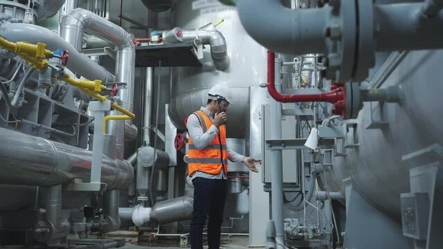 Industrial engineer working and communication for inspect factory and machine standards. Engineer male working at factory. Concept of industry, factory, environment and professional people.