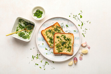 Composition with plate of toasted garlic bread, oil and greens on light background