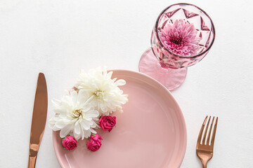 Beautiful table setting with chrysanthemum flowers and roses on white background