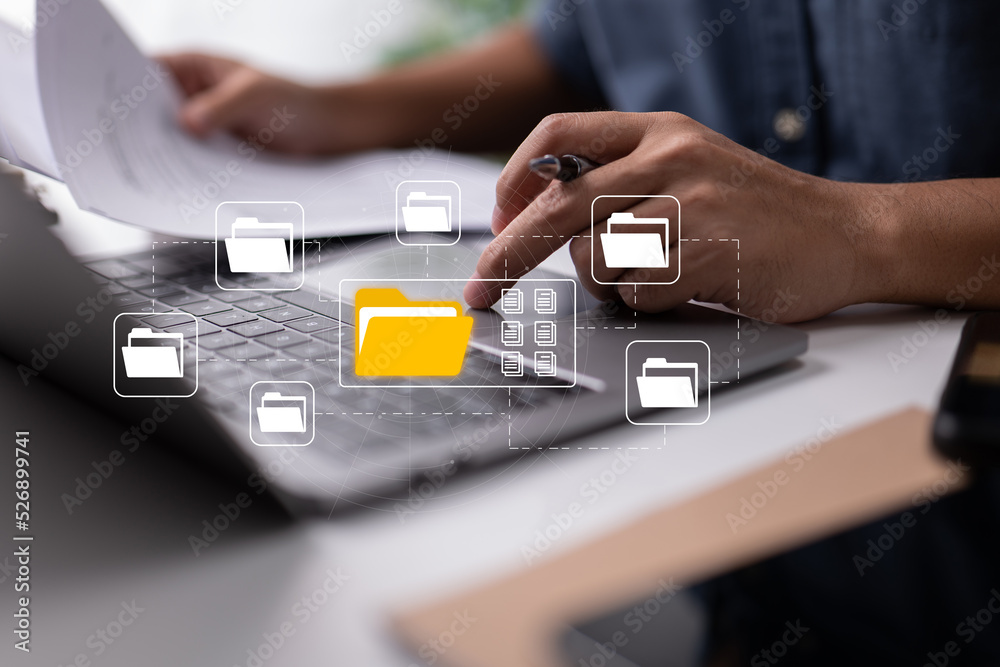 Poster Based on electronic documents, the paperless office concept. While looking at icons for electronic documents on a virtual screen, a businessman types on a laptop keyboard.