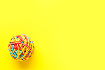 Colorful rubber band ball on yellow background