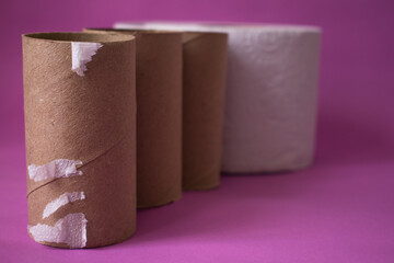 carton de papel higienico con un rollo nuevo desenfocado en un fondo lila