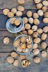 top view  on shelled walnuts in a glass jar among others on wooden table