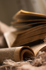 Rollo antiguo junto a libro abierto sobre tela rústica