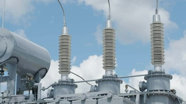 Many high voltage electrical insulators in power substation against blue sky background