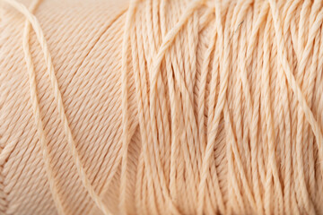 Macro texture of bright coral silk thread, close-up, copy space. Macro Photography of a coil with threads. Sewing background, screensaver. Abstraction, interweaving of shiny threads