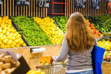woman at the fruit and vegetable market choosing products from the organic farm