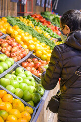 woman at the fruit and vegetable market choosing products from the organic farm