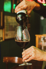 waitress serving glass of wine in restaurant at night
