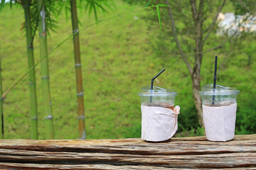A used plastic drink cups is placed on a wooden chair in the garden.