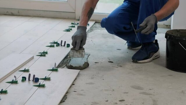 Installing ceramic floor tiles - measuring and cutting the pieces. Construction, renovation, repair apartment. Cuts tile. Tile cutting