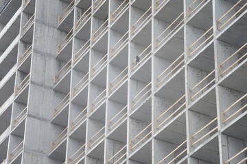 Full-color horizontal photo. Urban landscape. Part of the facade of a building under construction. Geometric linear composition with windows.