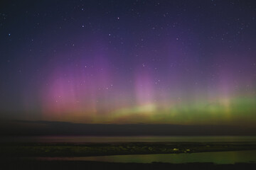 Intense northern lights aurora borealis over beach in Riga, Latvia. Defocused