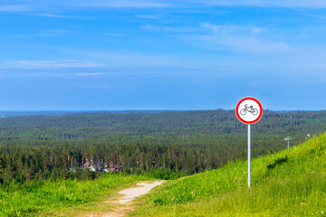 Round prohibition road sign No bikes stands near the trail