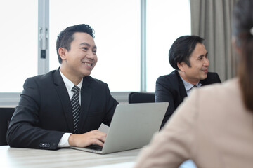 Collaborative process of professional businesspeople going over on new project together, using computer presentation and brainstorming ideas, coworker and working together at office meeting concept