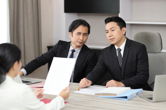 Human resources department managers sitting and interviewing female businesswoman applicant or candidate during job interview in modern office. Business recruitment concept