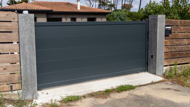 steel big grey metal gate slide fence on modern house access street