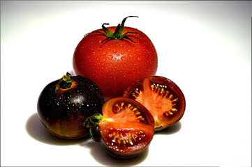 Czarne pomidory. Czerwony i czarny pomidor z kroplami wody na skórce. Dojrzałe warzywa. Warzywa do sałatki. Zdrowa dieta. Dieta warzywna.  - obrazy, fototapety, plakaty