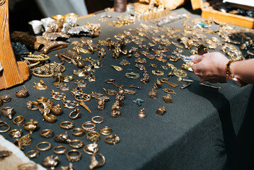 Craft handmade bronze jewelry, medieval amulets sold outdoors. Selective focus