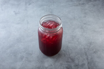 A view of a mason jar of jamaica agua fresca.