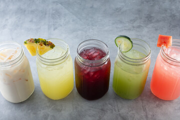 A view of a row of various agua fresca beverages.