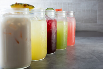 A view of a row of various agua fresca beverages.