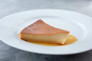A view of a slice of flan on a plate.