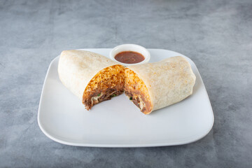 A view of a burrito cut open in the middle, showing its contents.