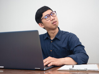 Asian businessman using laptop feels strain with working