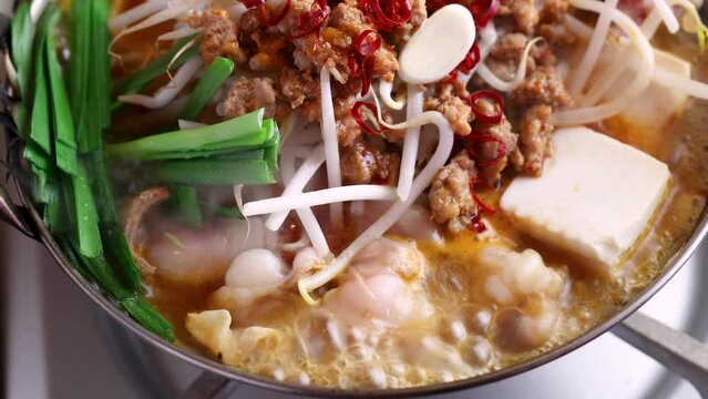 ピリ辛モツ鍋の〆雑炊に卵を投入