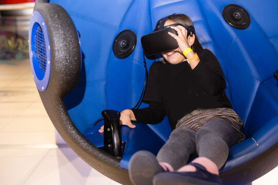 Child with virtual reality headset sitting in a chair booth