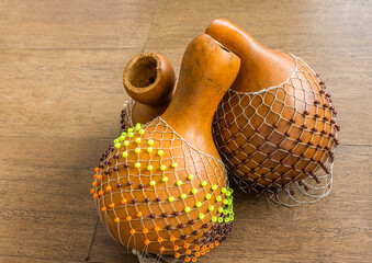 Originated in south west of Nigeria, shekere is a West African percussion instrument consisting of a dried gourd with beads or cowries woven into a net covering the gourd.