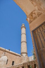 Low angle view of minaret of mosque in Mardin from beautiful engraving at entrance gate made of...