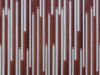 Crazy gate, close-up of a striped pattern in red and white with interesting lighting mood. The pattern is on an entrance gate.