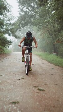 Extreme MTB athlete goes downhill on his bike in nature on a rainy day
