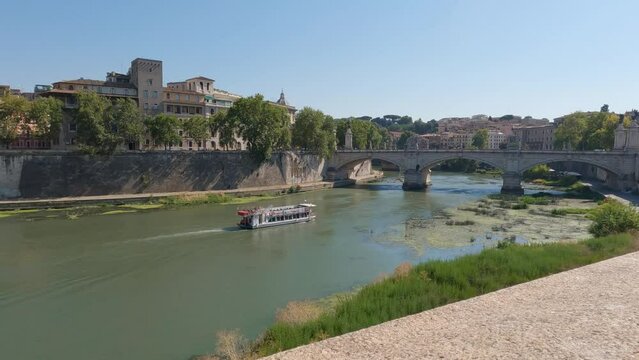 Tourist boat on the river Tiber near the famous bridge Ponte Sant Angelo in Rome