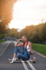 Winsome Attractive Caucasian Female Dressed in Trendy Stylish Streetwear Resting at Longboard During Sport Time in City Enjoying While Recreation Chill On Longboard