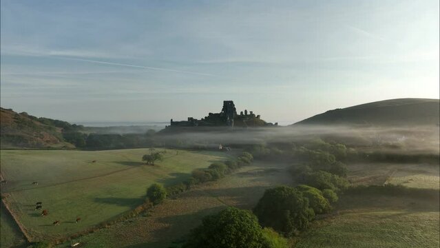 Corfe Castle, aerial view of the castle through morning mist, Dorset, UK.