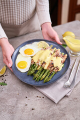 Healthy tasty breakfast - Asparagus wrapped with bacon and fried eggs on a plate