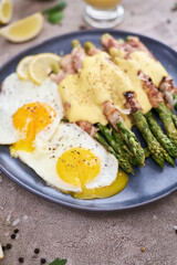 Healthy tasty breakfast - Asparagus wrapped with bacon and fried eggs on a plate