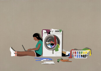 Girl using laptop and doing laundry at clothes dryer
