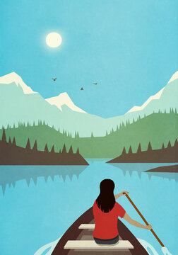 Woman canoeing on tranquil, idyllic summer mountain lake
