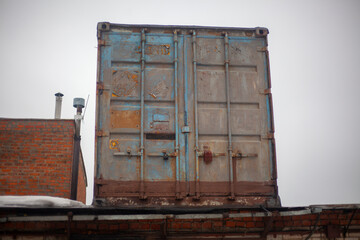 Container on roof. Steel container from stock. Old box.