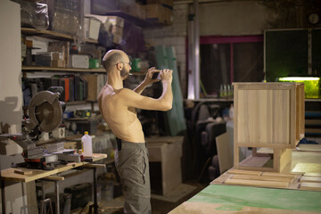 Fototapeta na wymiar Guy without T-shirt at work. Man takes pictures. Work for yourself.