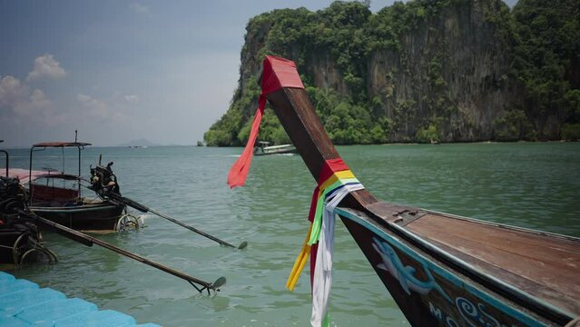 Thail long-tail wooden hopping tour boats moored at floating pierce in Railay Beach, Thailand