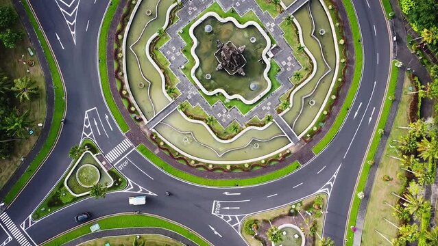 Birdseye Drone shot of traffic driving around beautiful roundabout