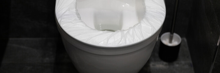 disposable cover pad on the rim of the toilet seat. wc hygiene system in public washroom. toilet...