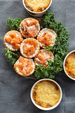 Still life view from above mini salmon tarts and cheese casserole
