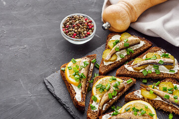 canapes with sprats on a black stone tray